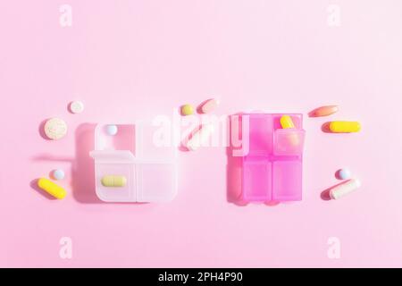 Pharmazeutische farbenfrohe medizinische Pillen, Tabletten, Kapseln und Tablettenbehälter auf pastellrosa Hintergrund. Hartes Licht, Studiofoto, Kopierraum. Stockfoto