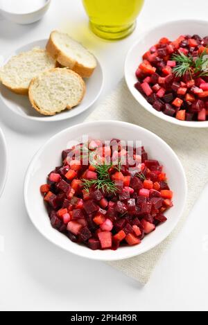 Gesunder Entgiftungssalat mit Rote Bete, Kartoffeln, Karotten, Gurken in der Schüssel auf weißem Hintergrund. Vegetarisches veganes Speisekonzept. Stockfoto