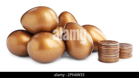 Viele goldene Eier und Münzen auf weißem Hintergrund. Pensionskonzept Stockfoto