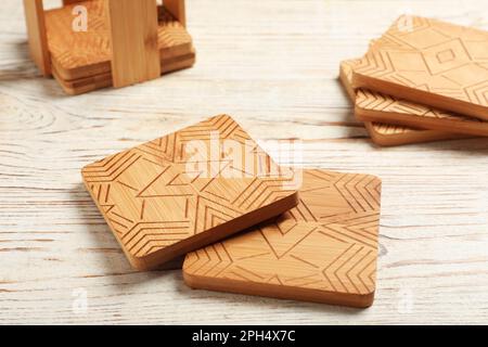 Stilvolle Untersetzer für Tassen auf weißem Holztisch Stockfoto