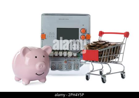 Stromzähler, pinkfarbenes Sparschwein und kleiner Einkaufswagen mit Münzen auf weißem Hintergrund Stockfoto