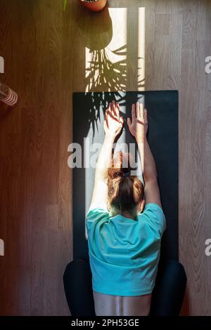 Selbstliebe mit gesundem Lebensstil, weibliche Person auf Yogamatte zu Hause. Stockfoto