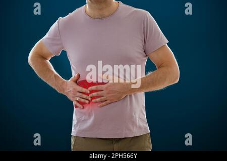 Der Mann, der seinen Magen vor Schmerzen hält. Männlicher Körper mit dem Bild einer entzündlichen Leber. Medizinisches Konzept Stockfoto