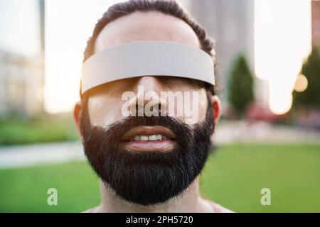 Junger Mann, der Spaß mit dem Augmented-Reality-Headset im Freien hat – Hauptaugenmerk auf der Nase Stockfoto