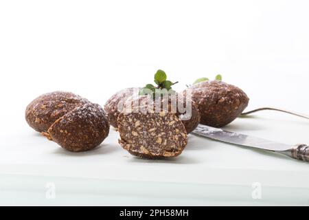 Schokoladensüßkuchen aus pürierten Keksen mit Zusatzstoffen, isoliert auf weißem Hintergrund. Stockfoto