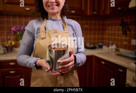 Details an den Händen einer lächelnden Hausfrau, Konditorin mit Backform und hausgemachtem Osterkuchen-Panettone Stockfoto