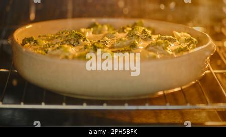 Backfisch mit Brokkoli unter Käse im Ofen Stockfoto