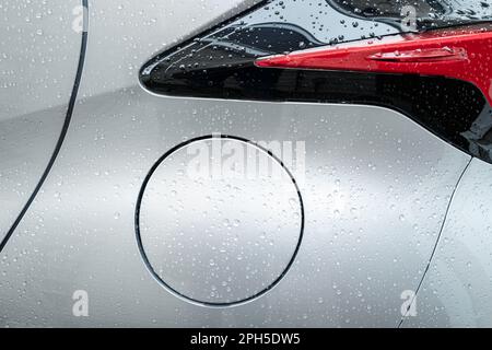 Nahaufnahme des Tankdeckels eines Hybrid-Stadtfahrzeugs. Zeigt die saubere Metalloberfläche nach einer Autowaschanlage. Stockfoto