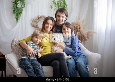 Mom, Kinder und Hund, die zu Hause rumalbern, und ihr Porträt im Frühling machen lassen Stockfoto