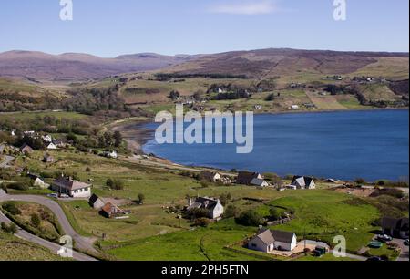 Blick über die Bucht von Uig und das umliegende Dorf an einem klaren, sonnigen Tag auf der Isle of Skye in Schottland Stockfoto