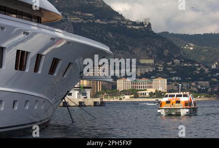 Kontrast zwischen dem Cunard Kreuzfahrtschiff Queen Elizabeth's und einer luxuriösen Superyacht in Port Hercule, Monte Carlo, Monaco. Stockfoto