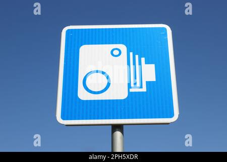 Niederwinkelansicht eines finnischen Verkehrsschilds mit einem Symbol für eine Kamera zur automatischen Verkehrsüberwachung vor klarem blauen Himmel. Stockfoto