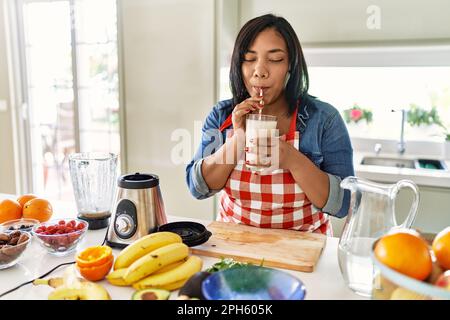 Hispanische Brünette Frau trinkt frischen Obst-Smoothie in der Küche Stockfoto