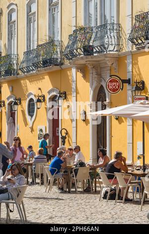 Gemütliche Cafés am Fluss in Tavira, wo die Menschen an einem sonnigen Frühlingstag essen und trinken. Stockfoto