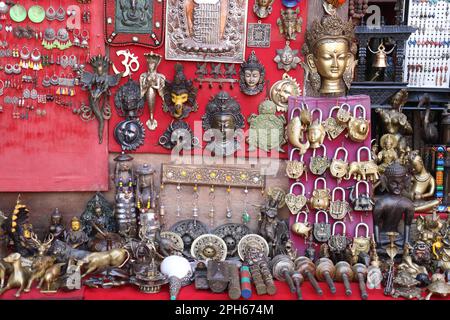 Eine Gruppe von handgefertigten, traditionellen Dekorationsgegenständen aus verschiedenen Materialien wie Messing, Kupfer und anderen schauten sich den buddha-Tempel in Nepal an. Stockfoto