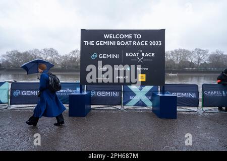 London UK 26. März 2023. Ein Fußgänger mit Schirm geht an einem nassen und regnerischen Tag am Horten am Putney River vorbei und begrüßt das Gemini Boat Race, da Tausende von Zuschauern erwartet werden, den Kurs von Putney nach Mortlake zu säumen, um das Männer- und Frauenboot Race zwischen Oxford und Cambridge Univeristy zu beobachten. Kredit: amer Ghazzal/Alamy Live News Stockfoto