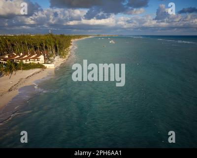 Palmenwald und Bungalows am Meer. Es gibt graue Sturmwolken am Himmel. Strandresort. Boote und ein Vergnügungsboot treiben im Meer. Ruh dich aus, entspann dich Stockfoto