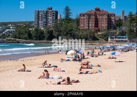 Genießen Sie die Sonnenstrahlen am Manly Beach, Sydney, New South Wales, Australien, während die Wellen des Pazifiks hereinrollen. Stockfoto