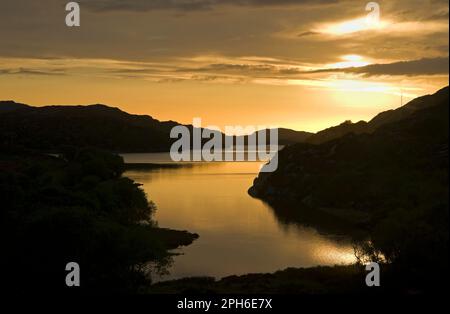 Dramatischer Sonnenuntergang über Loch Laxford, Sutherland, Scottish Highlands, mit Zusammenfluss mit der Mündung des Flusses Laxford im Vordergrund, Schottland Großbritannien. Stockfoto