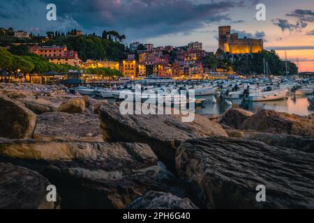 Eines der schönsten mediterranen Strandresorts. Malerischer Blick vom Hafen mit bunten Gebäuden und Burg auf der Klippe bei Sonnenuntergang, Lerici, Stockfoto