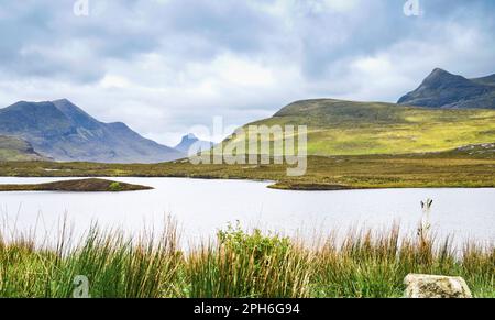 Cul Beag, Stac Pollaidh und Cul Mor über Lochan ein AIS-gesehen, durch Knockan Crag Visitor Centre, Northwest Highlands Geopark, Scottish Highlands, Großbritannien Stockfoto