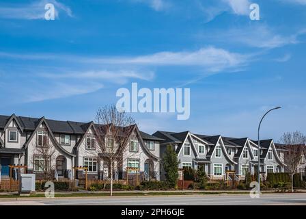 Brandneue, gehobene Stadthäuser in einem kanadischen Viertel. Schöne Stadthäuser. Außenfassade einer Reihe farbenfroher moderner Stadthäuser. Stockfoto