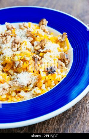 Gersten-Orzotto mit Winterkürbis und gerösteten Walnüssen. Stockfoto