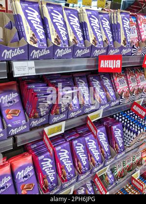 25.03.2023 Ukraine, Charkov Food Regal mit Schokolade, Milka Schokolade in der Hand. Stockfoto