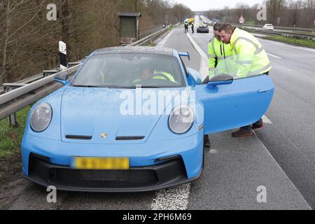 26. März 2023, Nordrhein-Westfalen, Emmerich: Ein Porsche parkt an der Schulter der A3 nahe Emmerich. Der 39-jährige Fahrer des Autos hatte angehalten, um den Insassen eines anderen Fahrzeugs zu helfen, das in den Unfall verwickelt war, sagte ein Sprecher der Düsseldorfer Autobahnpolizei. Als die Insassen des abgestürzten Autos und der Ersthelfer auf der Schulter standen, wurden alle drei von einem sich nähernden Auto getroffen, sagte er. Vier Menschen starben bei Unfällen in kurzer Folge auf der A3 nahe Emmerich am Niederrhein, darunter ein Ersthelfer. Rettungshubschrauber, Notärzte und Krankenwagen waren wieder da Stockfoto