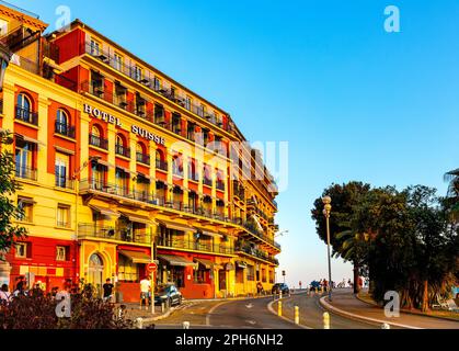 Nizza, Frankreich - 29. Juli 2022: Blick auf die Promenade Quai Rauba Capeu bei Sonnenuntergang neben dem Burgberg Colline du Chateau und dem historischen Swiss Hotel in Nizza Stockfoto