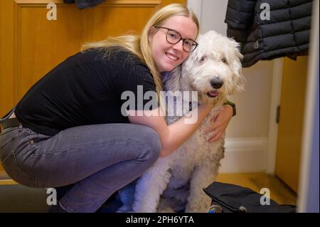 Eine Frau teilt einen Moment der Liebe und Zuneigung mit ihrem pelzigen Freund, einem wunderschönen alten englischen Schäferhund. Stockfoto