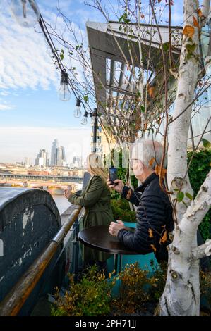 Sehen Sie London mit den Augen einer Frau, während sie den Panoramablick von der Terrasse des OXO Tower genießt. Stockfoto