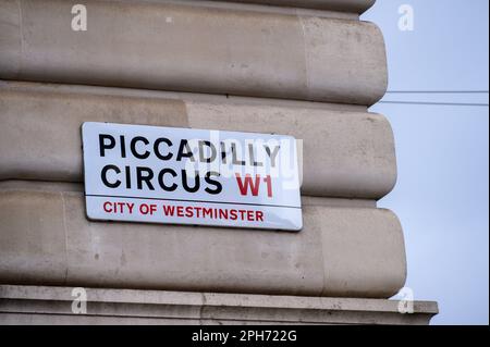 LONDON - 13. November 2022: Ein Straßenschild mit der Aufschrift „Piccadilly Circus, W1, City of Westminster“ an der Seite eines Gebäudes in London. Stockfoto