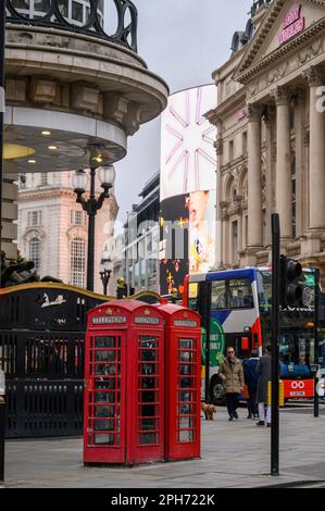LONDON - 13. November 2022: Die traditionellen roten Telefonzellen des Piccadilly Circus in London sind ein Symbol des britischen Erbes und ein beliebter Tourist Stockfoto