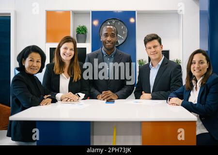 Gruppe positiver multiethnischer Geschäftsleute in formellen Anzügen Stockfoto