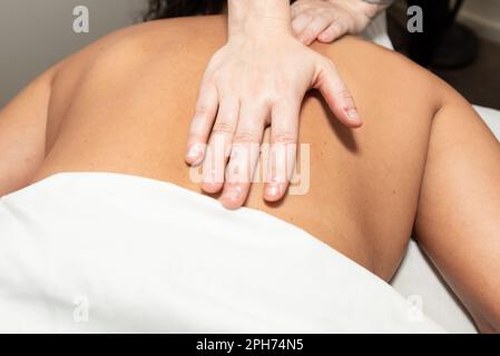 Massagetherapeutin starke Hände sorgen für langen und gleichmäßigen Druck der Handfläche auf muskelstimulierende Schlaganfälle. Stockfoto