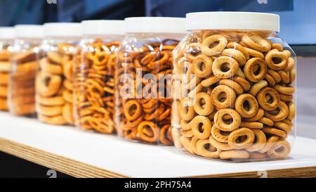 Snacks, Backwaren, Kekse, Bagels für Tee auf einem Holztisch. Bagels in einem Glasgefäß Stockfoto