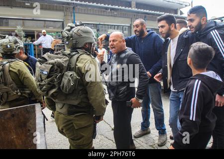 Nablus, Palästina. 26. März 2023. Die Palästinenser konfrontieren israelische Soldaten nach einem Schussanschlag auf zwei israelische Soldaten in der Stadt Hawara südlich von Nablus im besetzten Westjordanland. Unruhen zwischen Palästinensern, jüdischen Siedlern und israelischen Soldaten in der Stadt Hawara, nachdem die Siedler ein hartes Vorgehen gegen Palästinenser forderten, nachdem ein Palästinenser das Feuer auf einen Militärposten eröffnete und zwei israelische Soldaten verletzte. Das ist der dritte Schussanschlag in der Stadt diesen Monat. Kredit: SOPA Images Limited/Alamy Live News Stockfoto