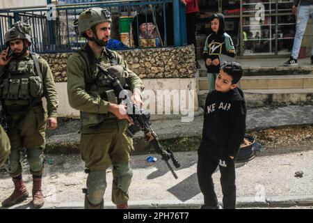 Nablus, Palästina. 26. März 2023. Israelische Soldaten sind nach einem Schussanschlag auf zwei israelische Soldaten in der Stadt Hawara südlich von Nablus im besetzten Westjordanland wachsam. Unruhen zwischen Palästinensern, jüdischen Siedlern und israelischen Soldaten in der Stadt Hawara, nachdem die Siedler ein hartes Vorgehen gegen Palästinenser forderten, nachdem ein Palästinenser das Feuer auf einen Militärposten eröffnete und zwei israelische Soldaten verletzte. Das ist der dritte Schussanschlag in der Stadt diesen Monat. Kredit: SOPA Images Limited/Alamy Live News Stockfoto