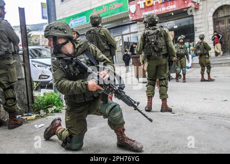 Nablus, Palästina. 26. März 2023. Israelische Soldaten nehmen nach einem Schussanschlag auf zwei israelische Soldaten in der Stadt Hawara, südlich von Nablus, im besetzten Westjordanland ihre Positionen ein. Unruhen zwischen Palästinensern, jüdischen Siedlern und israelischen Soldaten in der Stadt Hawara, nachdem die Siedler ein hartes Vorgehen gegen Palästinenser forderten, nachdem ein Palästinenser das Feuer auf einen Militärposten eröffnete und zwei israelische Soldaten verletzte. Das ist der dritte Schussanschlag in der Stadt diesen Monat. (Foto von Nasser Ishtayeh/SOPA Images/Sipa USA) Guthaben: SIPA USA/Alamy Live News Stockfoto