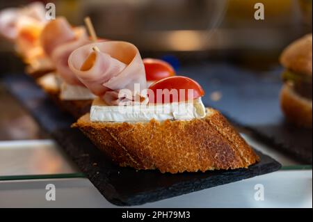 Typischer Mini-Burger-Snack aus dem Baskenland, Pinchos oder Pinxtos, kleines Stück Brot mit verschiedenen Belägen, serviert in der Bar in San-Sebastian oder Bilba Stockfoto