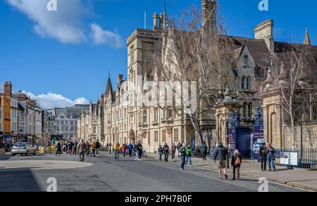 Touristen, die am 25. märz 2023 entlang der Broad Street neben der University of Oxford Balliol und Trinty Colleges in Oxford, Oxfordshire, Großbritannien spazieren Stockfoto