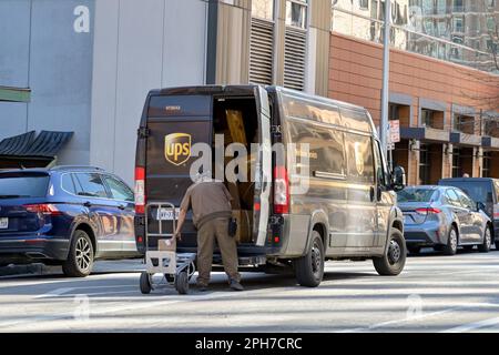 Austin, Texas, USA - Februar 2023: Person entlädt Pakete von einem UPS Lieferwagen im Stadtzentrum Stockfoto