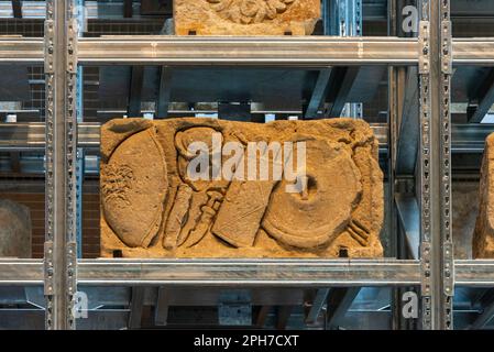 Ein geschnitzter Reliefstein mit Rüstung aus einem römischen Grab auf dem Regal der beeindruckenden Lapidärmauer im Narbo Via Roman History Museum in Narbonne. Stockfoto