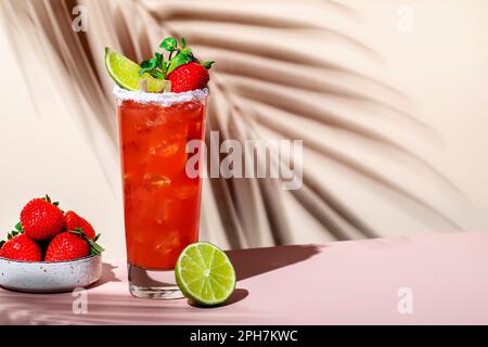 Paloma alkoholisches Cocktailgetränk mit Tequila, Grapefruit und Limettensaft, Erdbeeren, Minze und Eis im Glas mit salzhaltigem Rand. Beige rosa Vanille Backgr Stockfoto