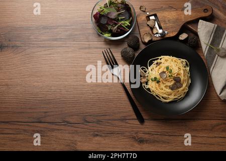 Leckere Spaghetti mit Trüffel, serviert auf einem Holztisch, flach liegend. Platz für Text Stockfoto