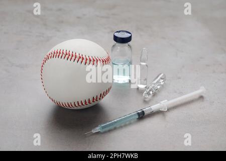 Baseballball, Spritze und Drogen auf hellgrauem Tisch. Dopingkonzept Stockfoto