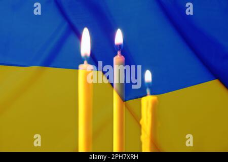 Doppelte Exposition der ukrainischen Nationalflagge und brennende Kerzen Stockfoto