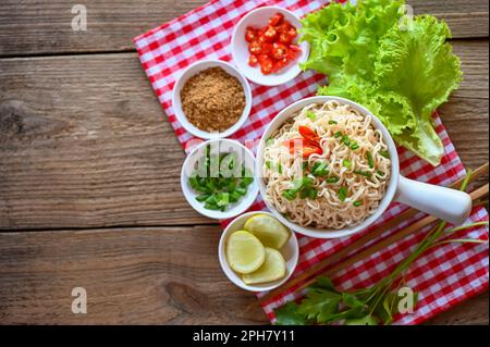 Nudelschüssel mit Gemüsebohnenzwiebeln, Zitronensellerie und Chili auf dem Tisch, Instant-Nudeln, kochen lecker mit Schüssel - Nudeln Stockfoto