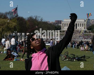 26. März 2023, Washington, District of Columbia, USA: Der ARYELLE Fountain hält sich fest an ihrem Drachen, während Hunderte anderer beim jährlichen Blossom Kite Festival in der National Mall dabei sind. Das Lincoln Monument ist im Hintergrund. (Kreditbild: © Sue Dorfman/ZUMA Press Wire) NUR REDAKTIONELLE VERWENDUNG! Nicht für den kommerziellen GEBRAUCH! Stockfoto